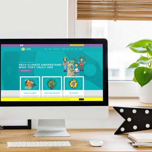 The Ignition! website homepage displayed on an iMac computer sat on a desk