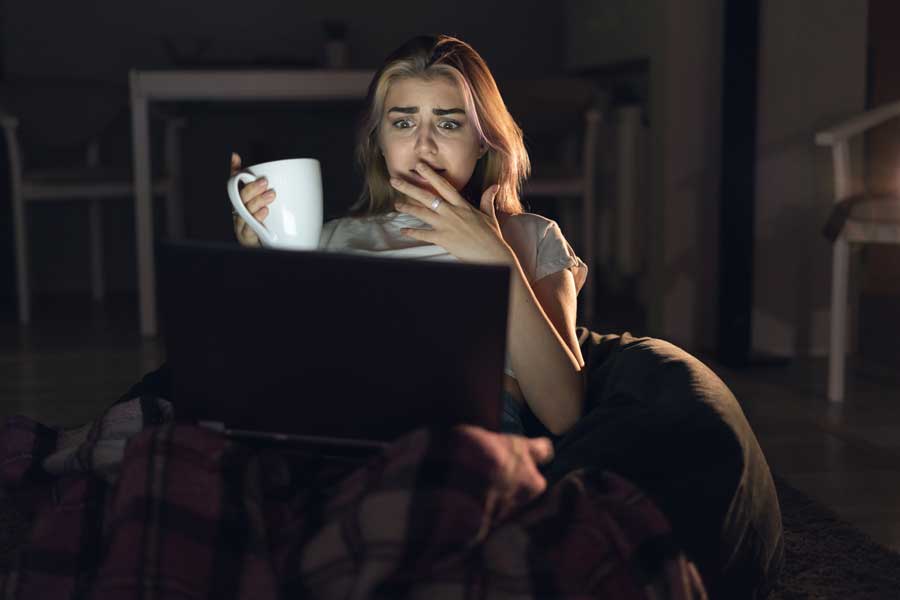 Woman sits with cup of tea and laptop and is horrified by a terrible website
