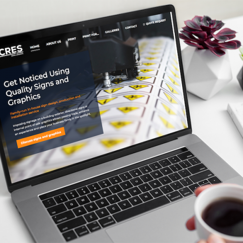 Acres signage and graphics website HomePage displayed on a MacBook