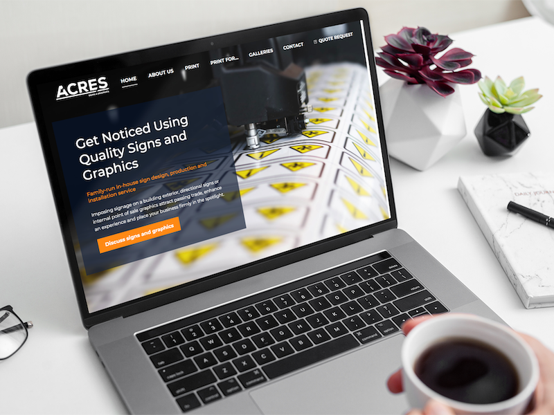 Acres signage and graphics website HomePage displayed on a MacBook
