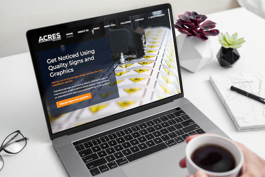 Acres signage and graphics website HomePage displayed on a MacBook